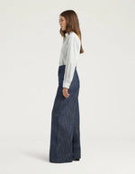 Profil du Pantalon 5 poches en jean droit bleu pour femme, modèle Aoki de la marque MOMONI. Présente une fermeture par bouton clou, un passepoil en M au dos et une étiquette en cuir.