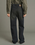 Dos du Jean ajusté taille haute pour femme en denim noir sépia avec jambe droite, braguette boutonnée et patch en cuir au dos, modèle Lucien de la marque Soeur.