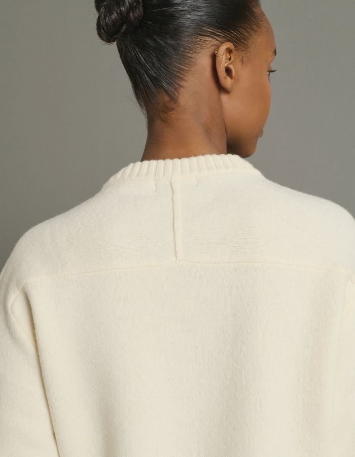 Détail du dos du Pull ajusté pour femme en maille feutrée écru 100% laine mérinos avec col rond et taille appuyée, modèle Jeremie de la marque Soeur.