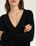 Col du Pull pour femme en pure laine noire, modèle Astrid de la marque MOMONI. Présente une maille teinté en pièce et de délicates bordures en lurex doré aux finitions.