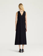 Dos de la Robe mi-longue sans manches en satin de viscose noir, modèle Eisla de la marque MOMONI. Présente une coupe fluide évasée, un décolleté V satiné brillant et un nœud à la nuque