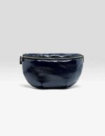 Face du Sac banane bandoulière pour femme en simili-cuir brillant bleu marine matelassé motif vagues avec bandoulière ajustable en coton, modèle Hosie Sling Bag de la marque Bellerose.