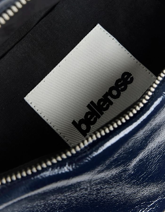 Intérieur du Sac banane bandoulière pour femme en simili-cuir brillant bleu marine matelassé motif vagues avec bandoulière ajustable en coton, modèle Hosie Sling Bag de la marque Bellerose.