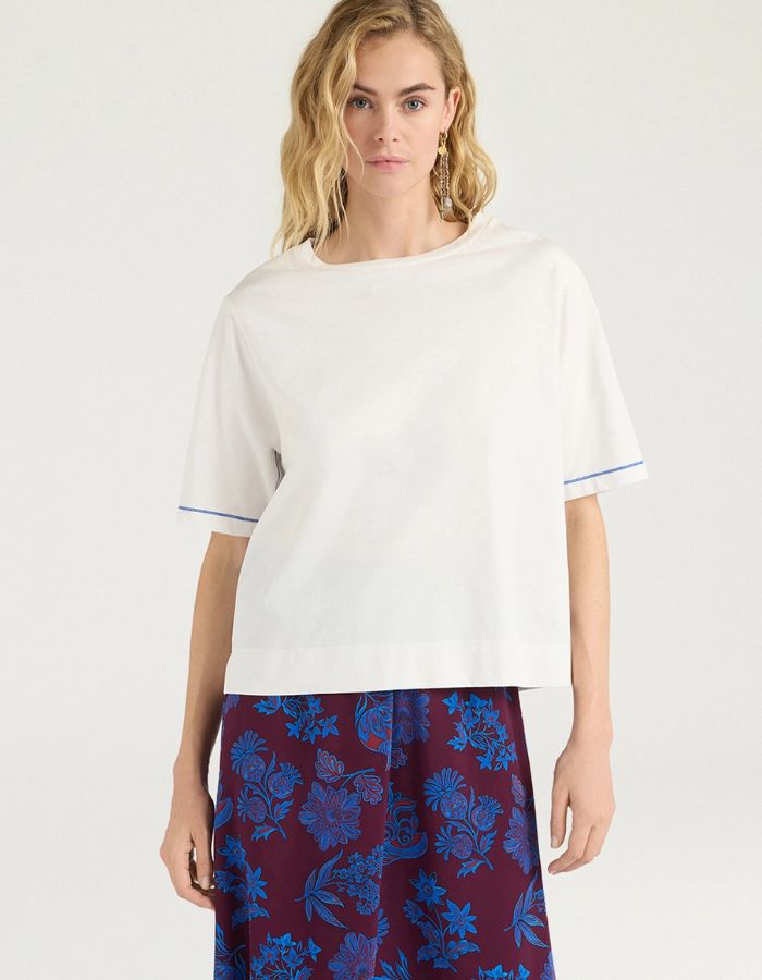 Vue de face du T-shirt oversize à manches courtes pour femme en jersey de coton blanc lurex, modèle Iora de la marque MOMONI. Présente une encolure ronde et de petites fentes latérales.