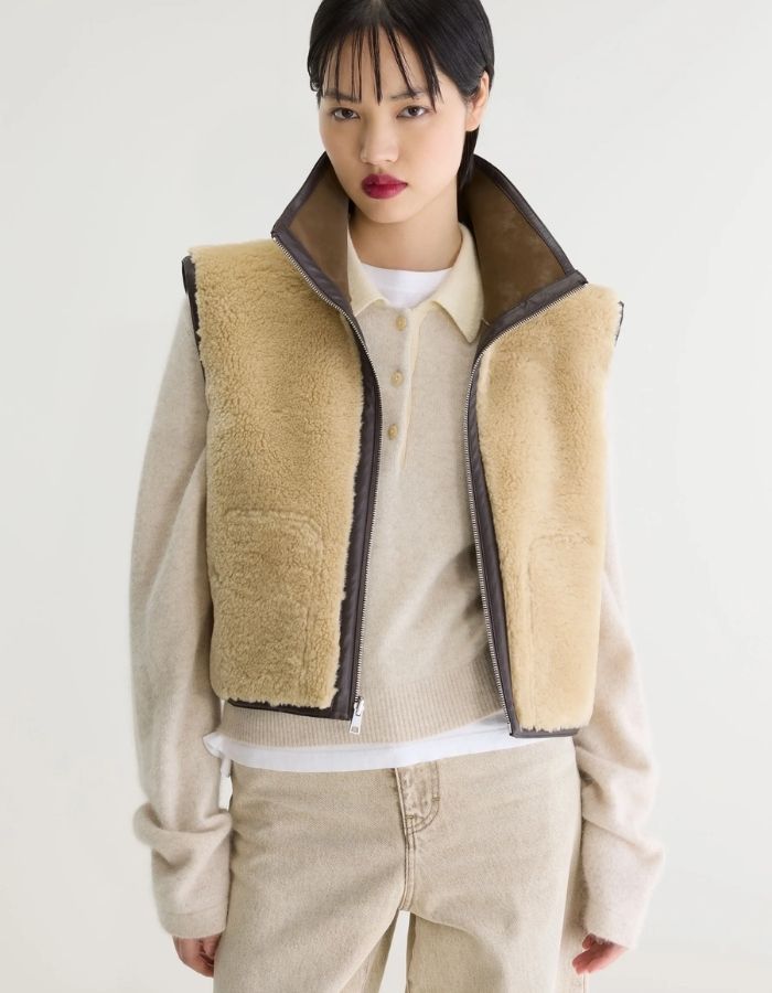 Face verso de la Veste courte sans manches réversible pour femme en sherpa beige et nubuck marron avec col montant et détails de coutures façon cuir, modèle Jonson de la marque Bellerose.