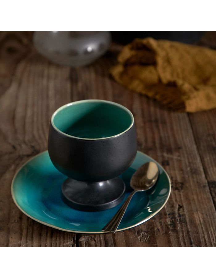 Assiette à dessert Riviera Costa Nova en grès fin turquoise craquelé avec bol noir et cuillère.