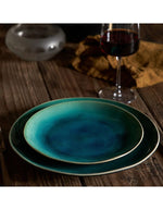 Deux assiettes à dessert Riviera en grès fin, émail craquelé bleu-vert dégradé, sur table en bois.