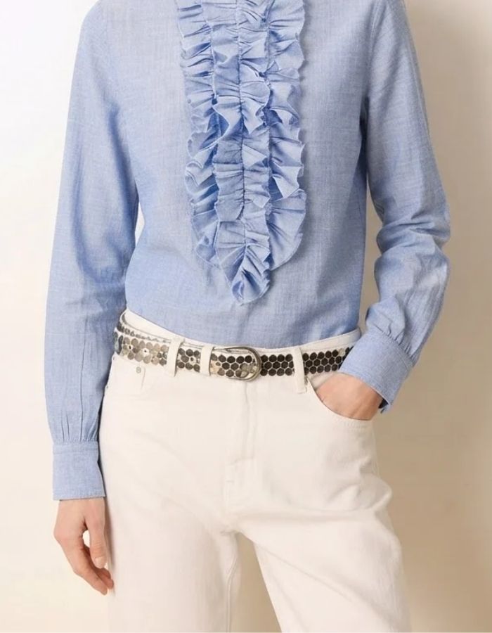 Vue de face de la Blouse fluide bleu ciel en coton pour femme avec col officier, manches longues froncées et fermeture boutonnée sous volant, modèle Carita Light Blue de la marque Laurence Bras.