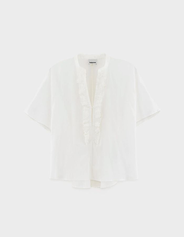Blouse Dahlia Blanche Bellerose en coton blanc, coupe oversized, col mandarin et volants sur la patte de boutonnage.