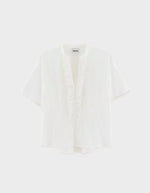 Blouse Dahlia Blanche Bellerose en coton blanc, coupe oversized, col mandarin et volants sur la patte de boutonnage.