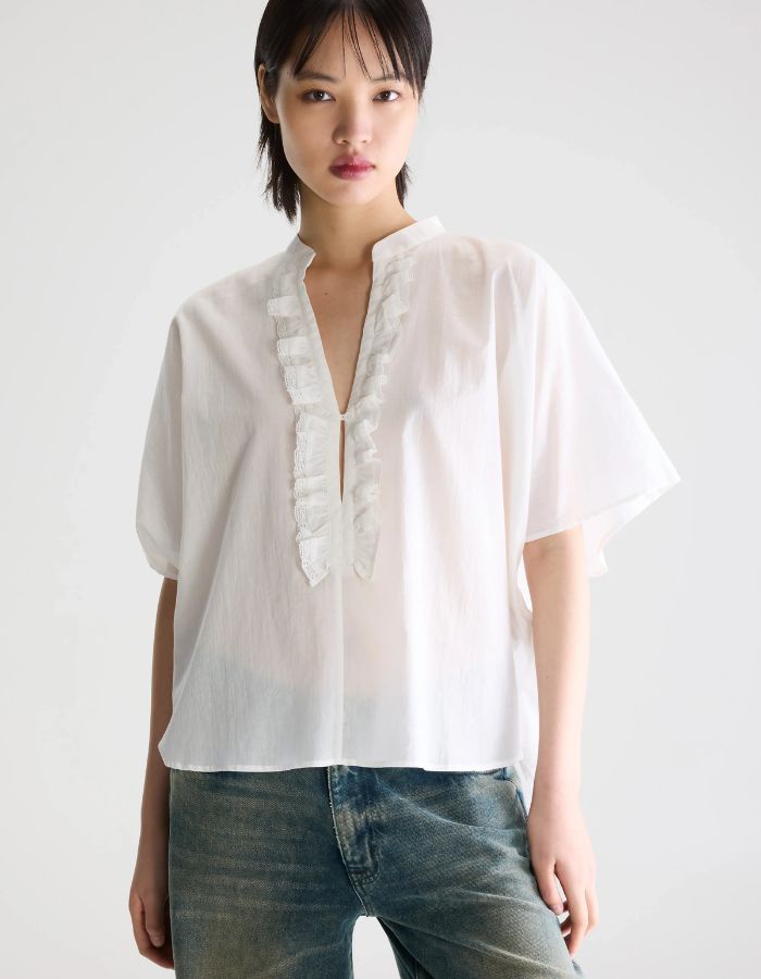 Blouse Dahlia Blanche Bellerose en coton blanc, coupe oversized, col mandarin et volants sur la patte de boutonnage.