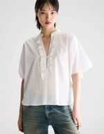 Blouse Dahlia Blanche Bellerose en coton blanc, coupe oversized, col mandarin et volants sur la patte de boutonnage.