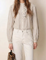 Silhouette avec la Blouse blanche ample en coton pour femme à rayures tissées avec col rond, manches bouffantes, plis plats et volants asymétriques sur le devant, modèle Fa de la marque Laurence Bras.