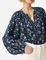 Blouse Gédéon Vanessa Bruno bleu marine à motif floral blanc, encolure en V froncée, manches longues bouffantes.