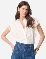 Blouse Gifty Ecru en coton avec manches volantées brodées, portée avec un jean bleu.