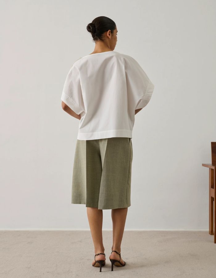 Blouse Issa Blanc Casse Soeur en coton biologique, coupe ample, col tombant, et ouverture boutonnée à l'épaule.