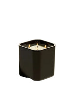 Bougie Facettes Ambre Noire 650Gr Maison Sarah Lavoine, bougie noire carrée à angles biseautés avec trois mèches allumées.
