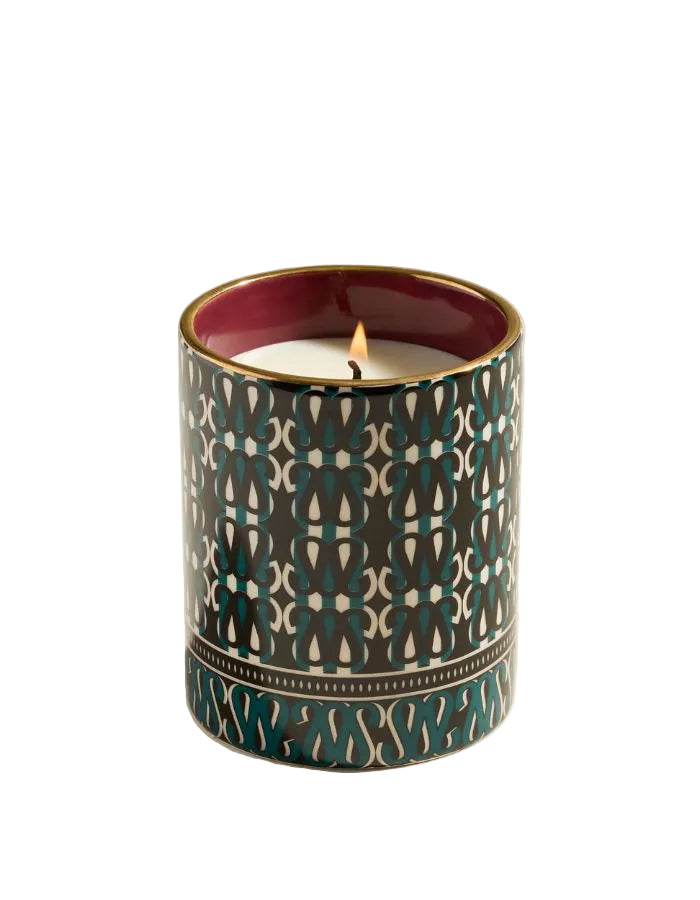 Bougie Sarah Bleu Sarah en grès avec motif géométrique vert foncé et blanc, liseré doré, flamme allumée.