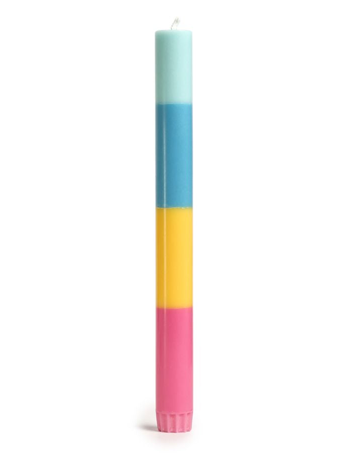 Bougie flambeau multicolore et graphique modèle Thanks de 23 cm de haut. Design minimaliste composé de couches de cire végétale biologique superposées à la main, présentée à côté de son étui cylindrique en papier de création certifié FSC