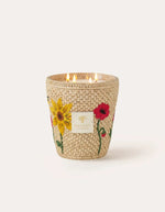 Bougie parfumée de luxe Vony Ahitra modèle max16 par Baobab Collection. Photophore recouvert de raphia naturel avec broderies artisanales colorées représentant des fleurs des champs (coquelicots, lavande). Design textile fait main à Madagascar.