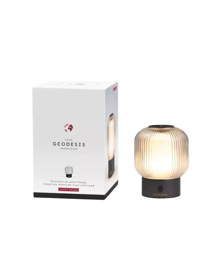 Brumisateur de parfum Prestige Geodesis noir et blanc avec cloche en verre strié et lumière chaude, à côté de sa boîte.