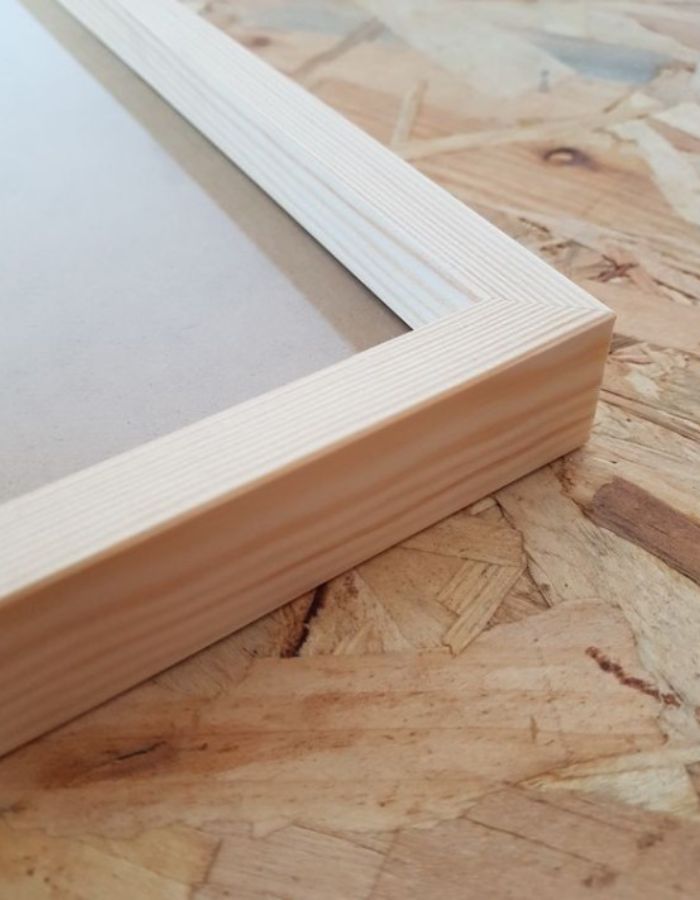 Cadre en bois naturel de pin clair, format A2, avec bords profonds de 25 mm sur un fond texturé.