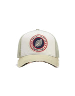 Casquette trucker Sweet Pants bicolore argile et blanc cassé avec patch logo feuille, visière destroy et dessous léopard.