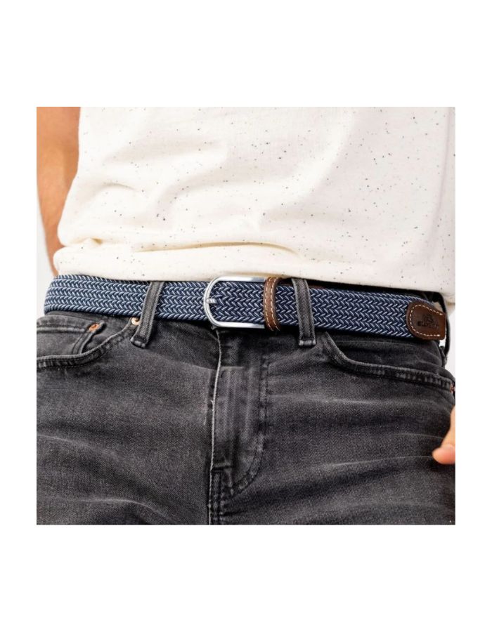 Ceinture tressée élastique bleu marine avec motif chevron, finitions cuir marron et boucle argentée, portée sur un jean.