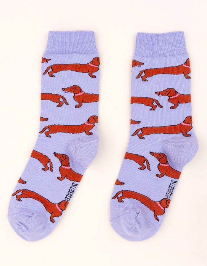Chaussettes lilas en coton avec motif teckels roux et colliers roses, marque Coucou Suzette.