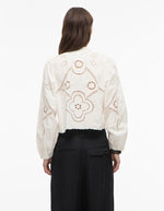 Chemise blanche Carin en popeline de coton bio avec broderie anglaise florale au dos et manches longues.