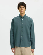 Silhouette avec la Chemise pour homme Clay de la marque SELECTED en mélange lin et coton, coloris vert Balsam. Coupe Regular Fit, manches longues et col boutonné classique. Matière texturée intégrant du coton recyclé