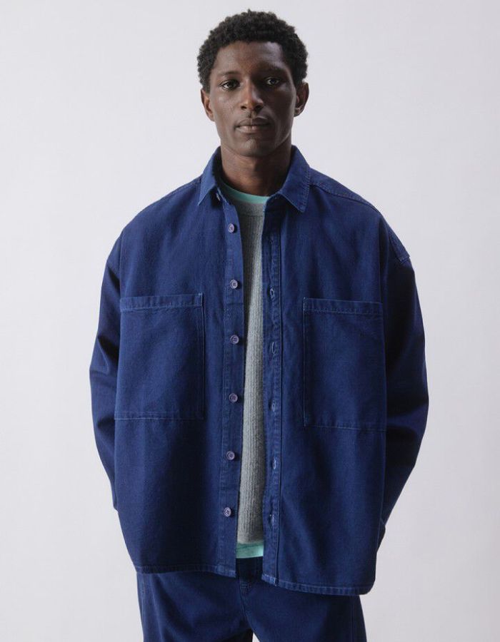 Vue de face de la Chemise en denim brut bleu foncé pour homme, modèle Comow de la marque American Vintage. Coupe ample et oversize, dotée de manches longues, de deux poches plaquées sur la poitrine et d'un col chemise classique. Au dos, le logo de la marque apparaît discrètement grâce à une finition gravée au laser