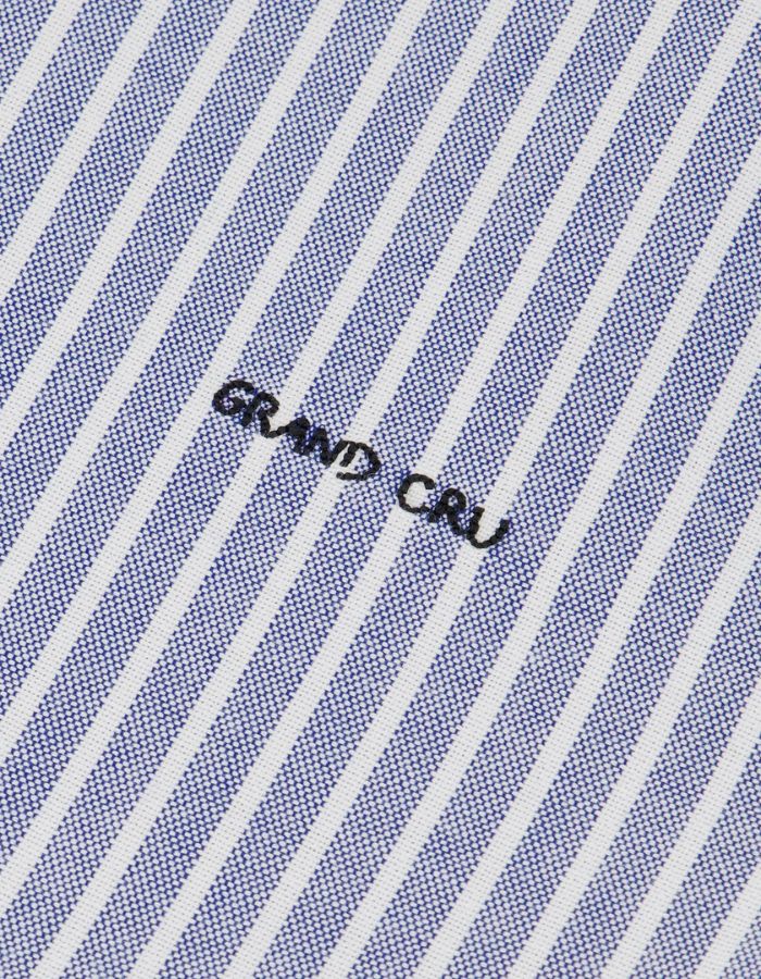 Broderie de la Chemise ajustée pour homme en coton Oxford à fines rayures bleu marine et blanches, modèle Malesherbes de la marque Maison Labiche. Présente un col boutonné, des boutons gravés et la mention 'Grand Cru' brodée en lettres fines sur la poitrine.