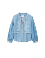 Chemise Laura Ba&sh en chambray denim clair avec effet gilet superposé et broderies blanches.