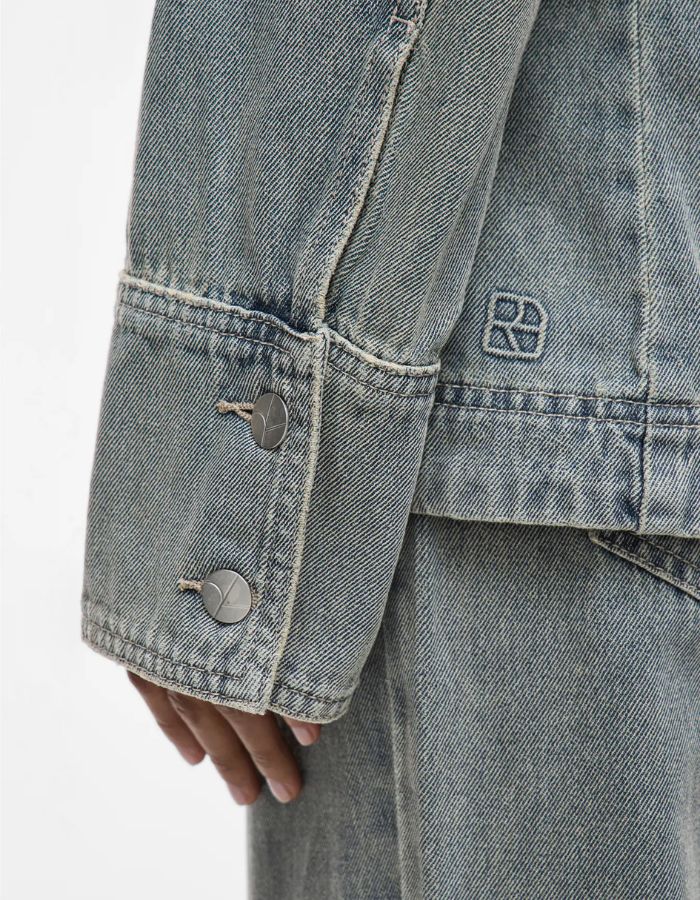 Manche longue de chemise en denim bleu clair avec deux boutons et logo brodé.