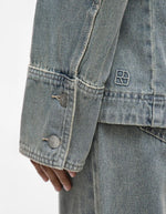 Manche longue de chemise en denim bleu clair avec deux boutons et logo brodé.