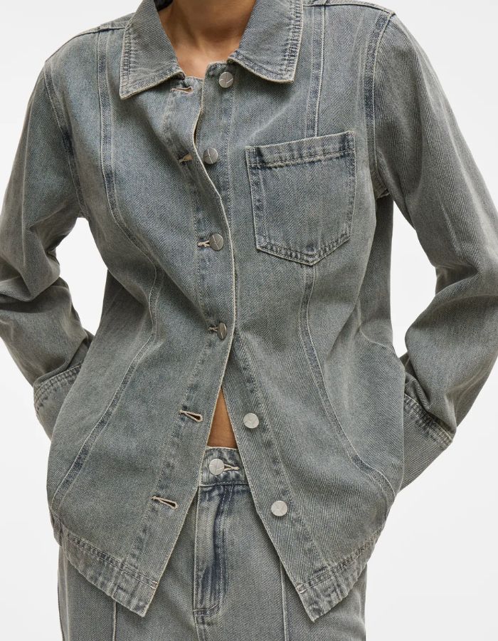 Chemise en denim Vivian bleu clair avec col, manches longues, fermeture boutonnée et poche poitrine.