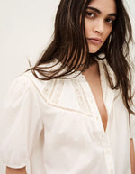Chemise Nella Ecru en voile de coton bio, coupe fluide, manches courtes, col rond avec dentelle et patte de boutonnage.