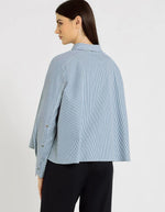 Dos de la Chemise évasée à rayures bleu indigo pour femme, modèle Grace de la marque Hana San. Présente une patte de boutonnage cachée, une emmanchure marteau et de longues pattes poignets boutonnées.