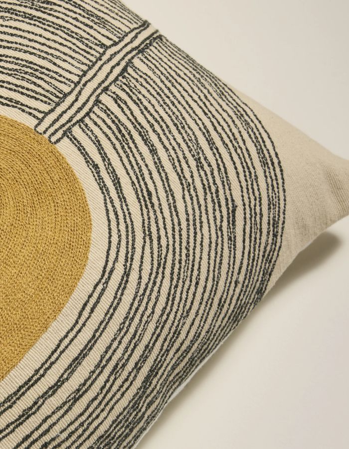 Détail de finition du Coussin rectangulaire Mirage par Maison Sarah Lavoine. Fond textile avec motifs brodés main aux lignes organiques coloris Vert Forêt et Ocre, composition coton et laine, dimensions 50x30 cm.