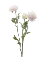 Fleur artificielle renoncule rose pâle et crème avec feuilles vertes, aspect réaliste.