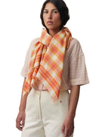 Foulard 768 Natural Moismont en coton léger, motif ikat à carreaux orange, jaune et blanc, bords frangés.