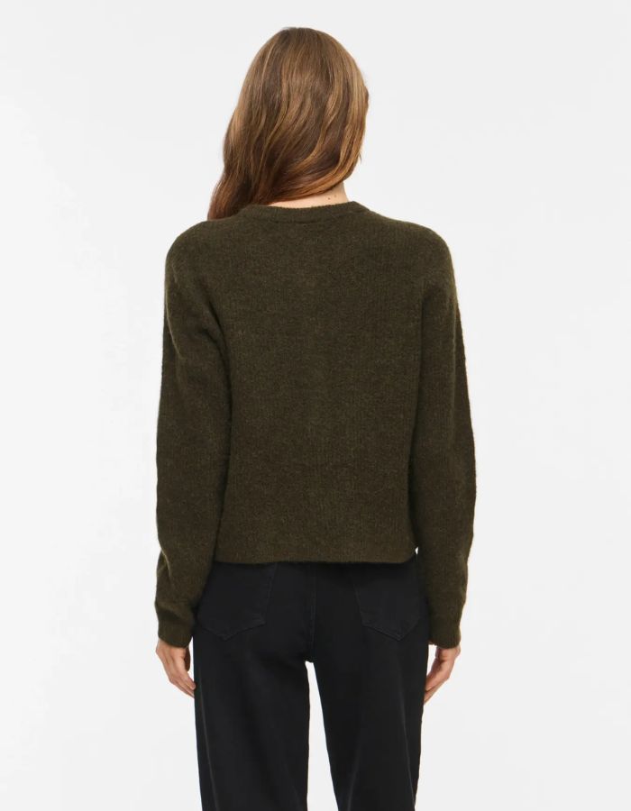 Silhouette de dos avec le Gilet col rond pour femme en maille vert forêt chiné Forest Night Melange, modèle Lory O-Neck Cardigan de la marque VILA. Présente des manches longues, des boutons sur le devant et des finitions en bord-côte au col, aux poignets et au bas.