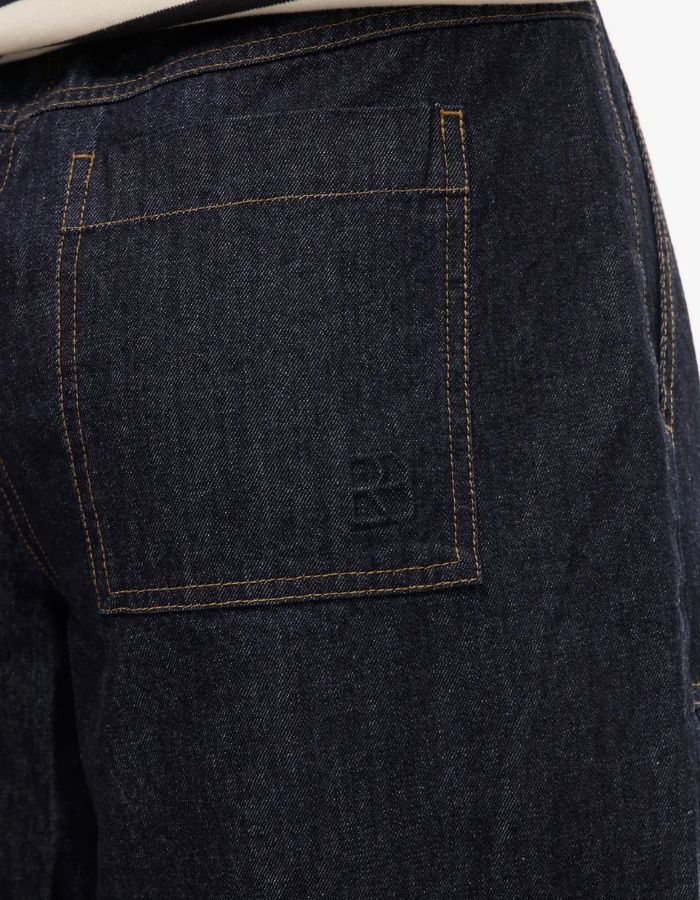 Jean Brixton coupe droite en denim bleu foncé avec surpiqûres camel et logo brodé sur la poche arrière.
