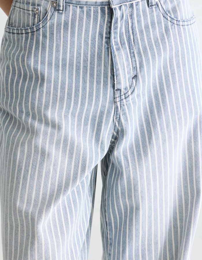 Jean denim bleu délavé à rayures verticales écrues, coupe relaxed boyfriend, taille mi-haute.