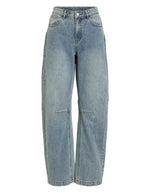 Jean pour femme de couleur bleu clair délavé Light Blue Denim, modèle Tiana de la marque Rouge Edit. Présente une coupe droite ample contemporaine, une taille mi-haute avec des passants de ceinture et des finitions de boutons en métal doré mat Dull Gold.
