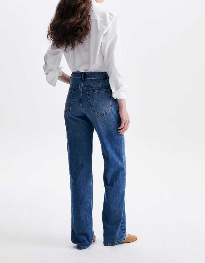 Détail de la taille haute et du denim bleu du jean Ryder