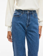 Bassin avec le Jean large pour femme de couleur bleu moyen Medium Blue Denim, modèle Reya de la marque Vila. Présente une taille haute ajustée et des jambes amples fluides (coupe Frida), avec une fermeture par zip.