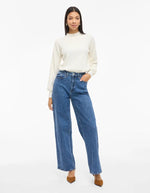 Silhouette avec le Jean large pour femme de couleur bleu moyen Medium Blue Denim, modèle Reya de la marque Vila. Présente une taille haute ajustée et des jambes amples fluides (coupe Frida), avec une fermeture par zip.