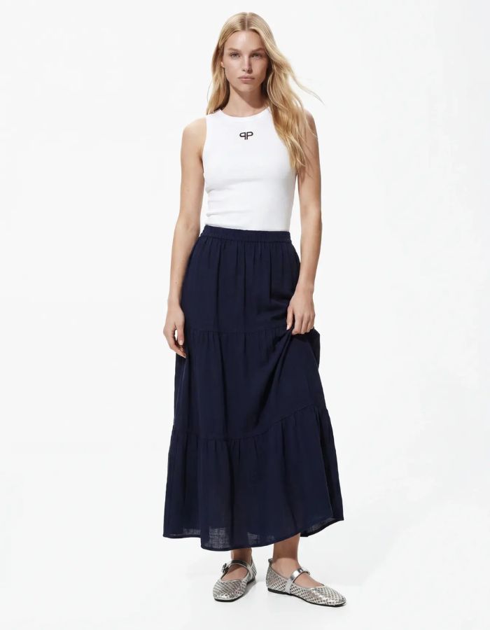 Silhouette avec la Jupe longue taille haute Tohime par Pieces de couleur bleu marine (Maritime Blue). Coupe fluide longueur cheville en pur coton avec de délicates bandes de dentelle horizontales.